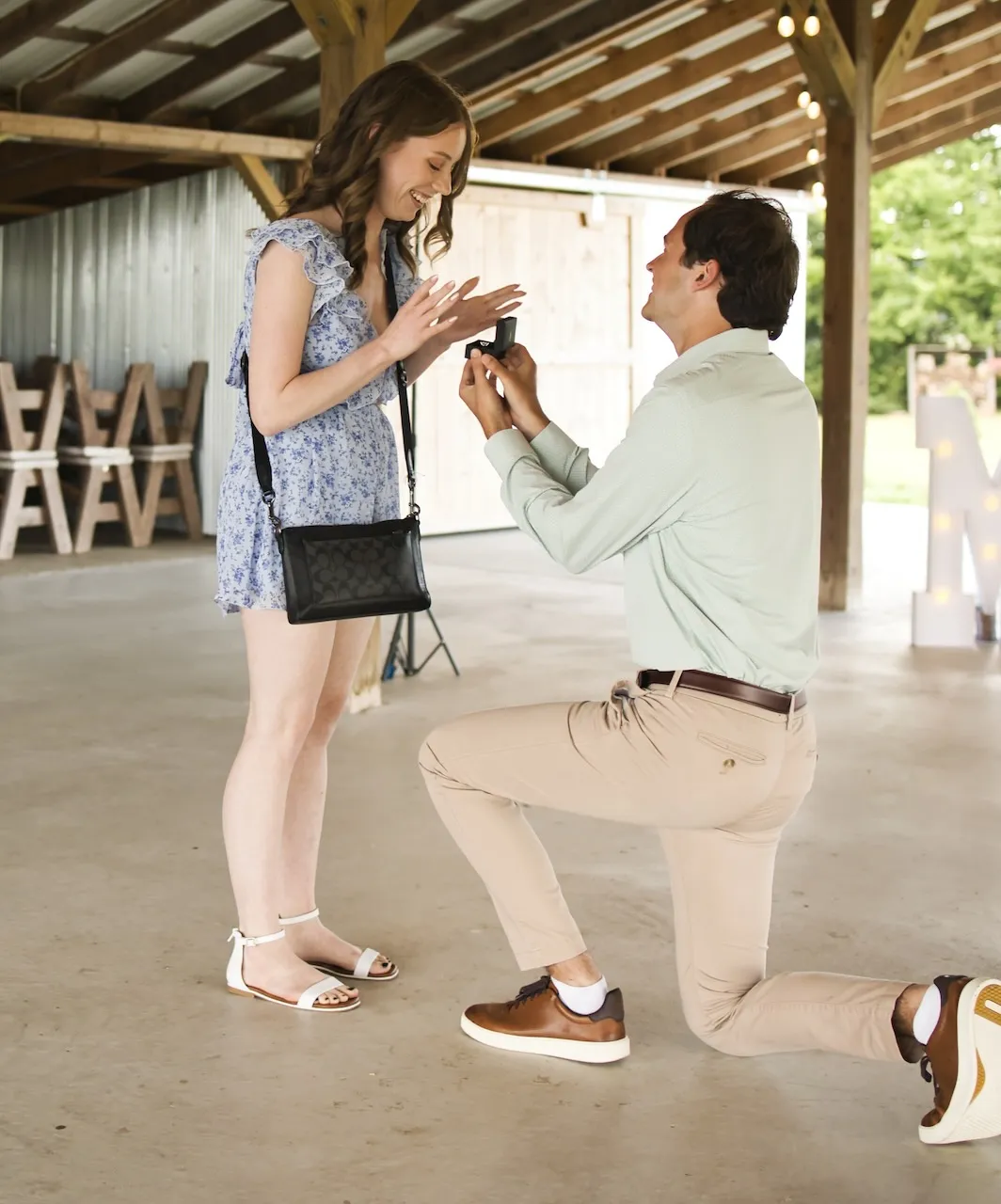 Josh on one knee proposing to Jess.