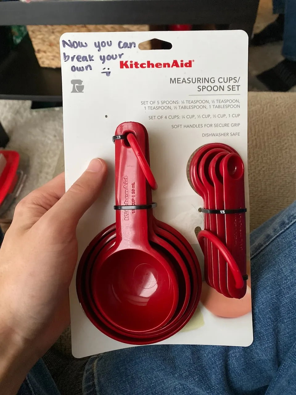 New set of red measuring cups with the text 'Now you can break your own' handwritten on the packaging